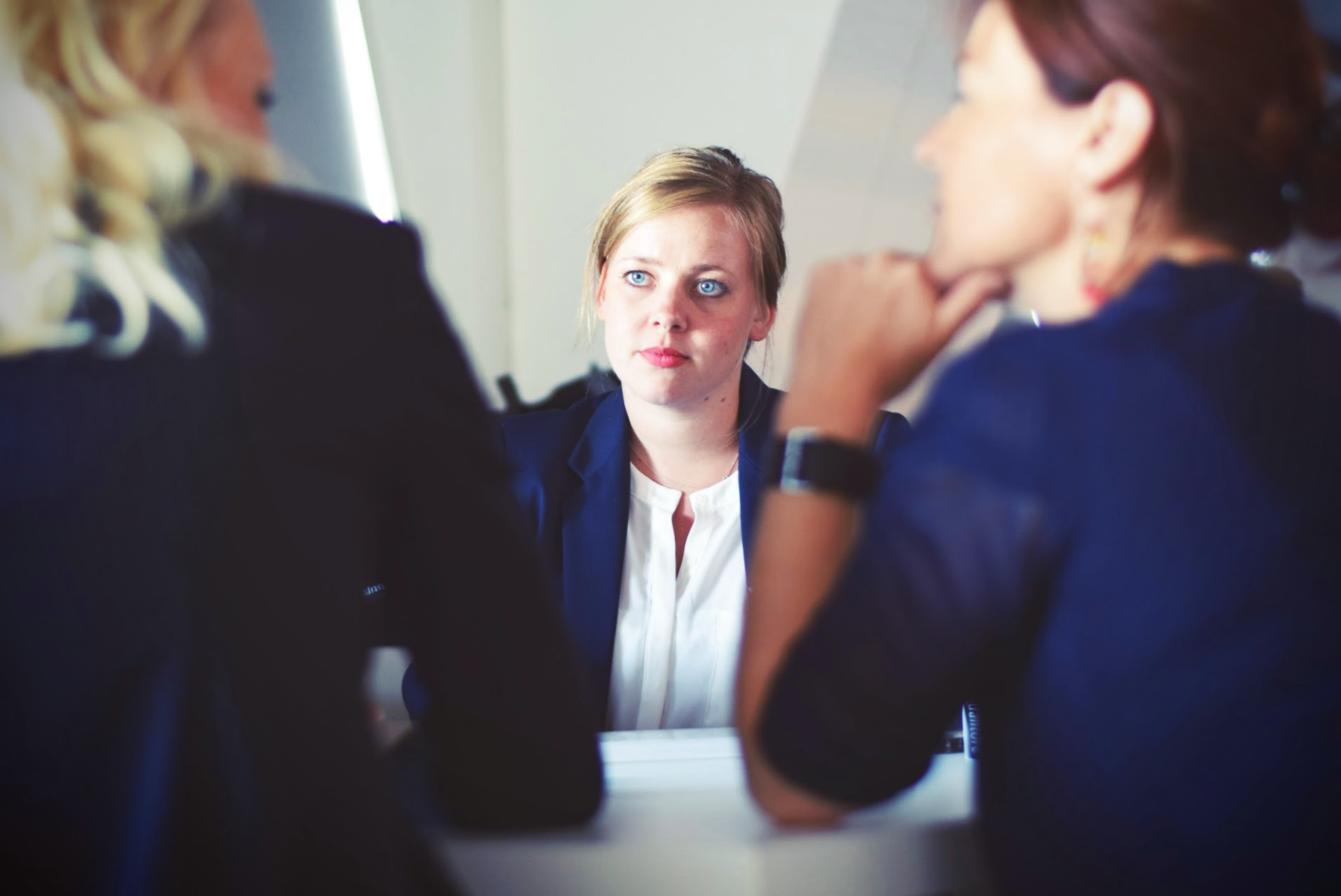 Three professional women sitting down and talking 