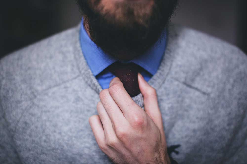 Close-up of a man as he adjusts his tie 