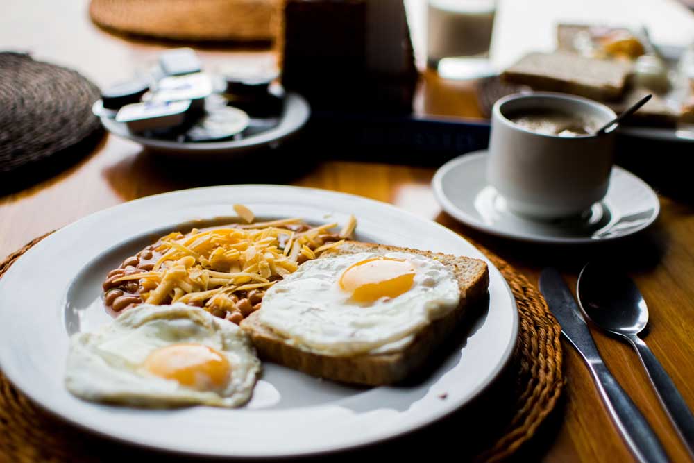 Eggs on toast and beans with cheese and coffee in a diner