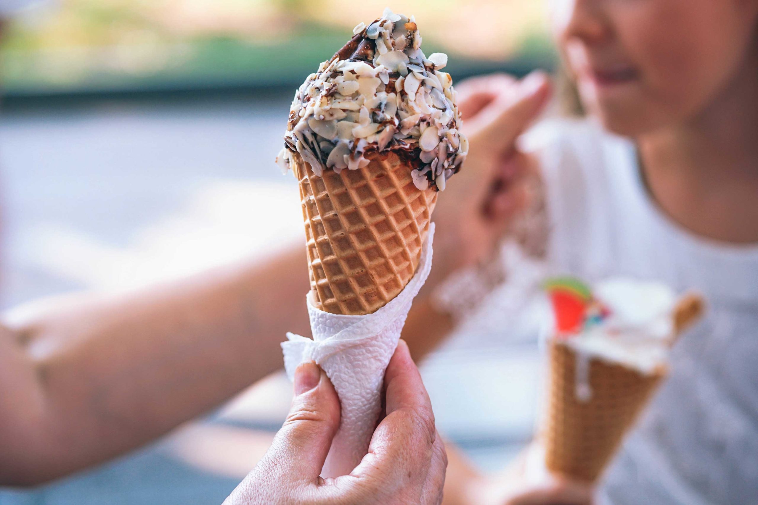 Waffle ice cream cone covered in chocolate and nuts