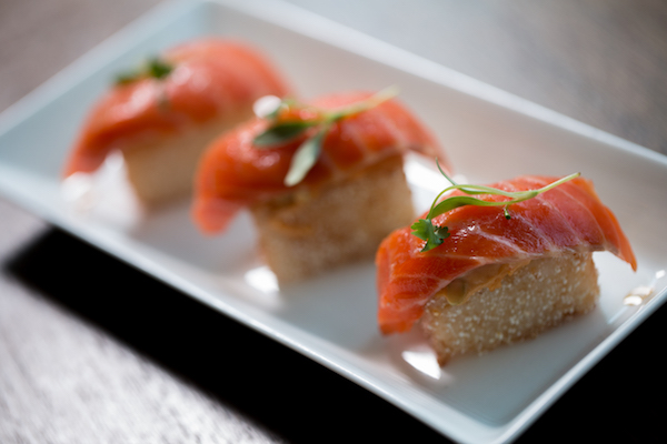 Three salmon sushi on a plate at Market