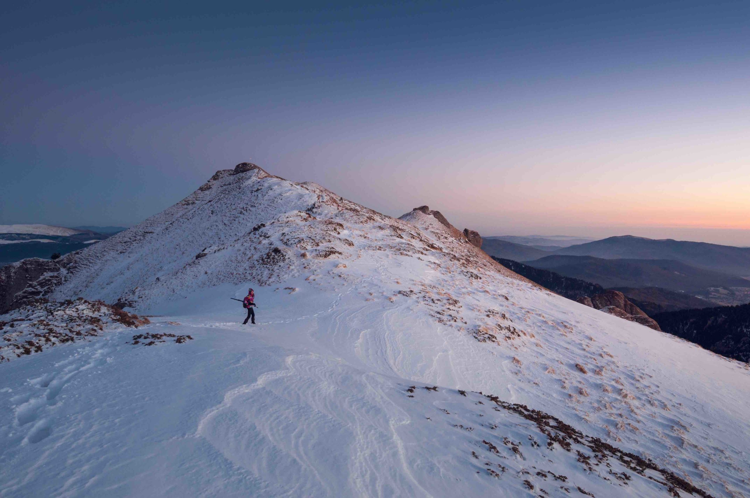 A person hikign on a snow-capped mountain