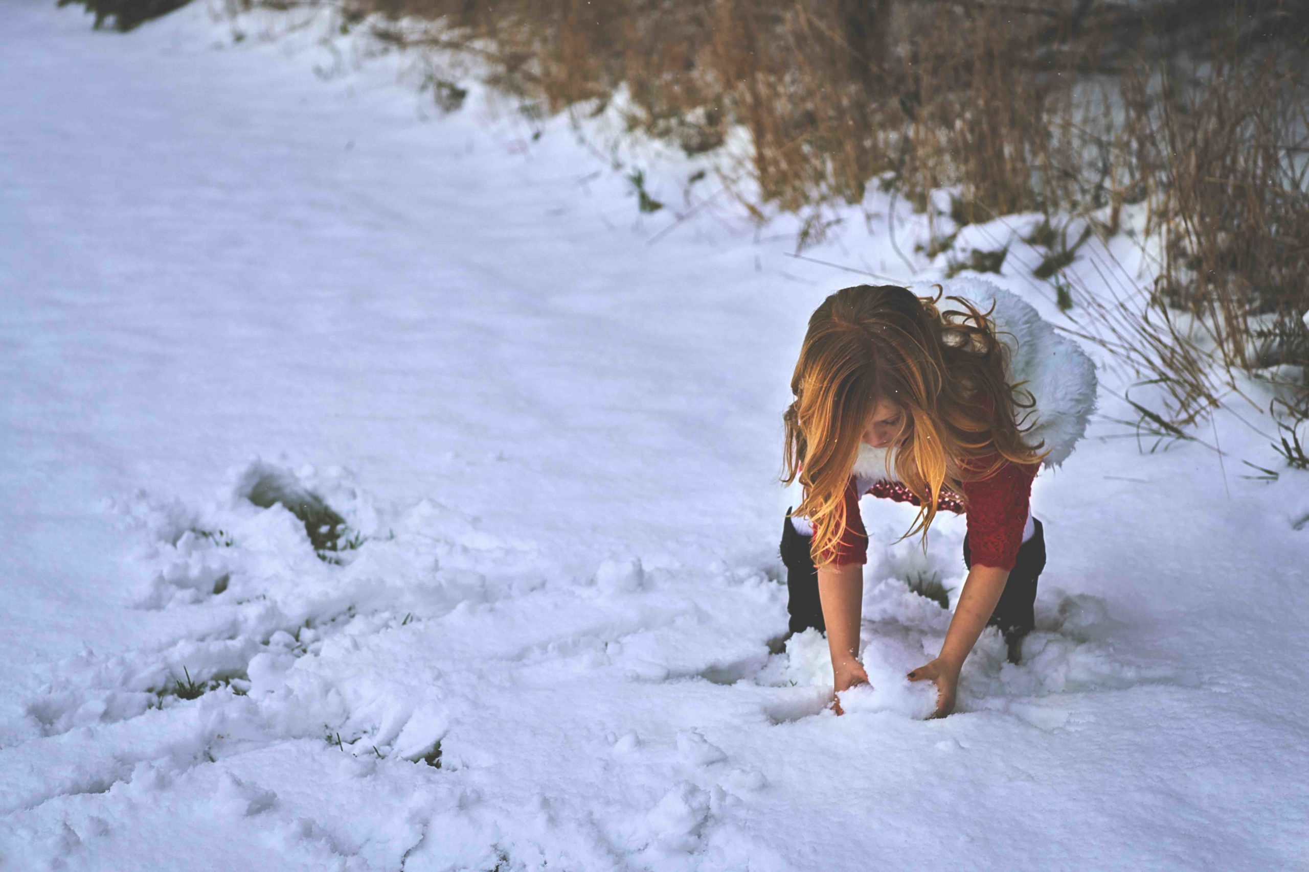 A woman collects snow to make a snowball