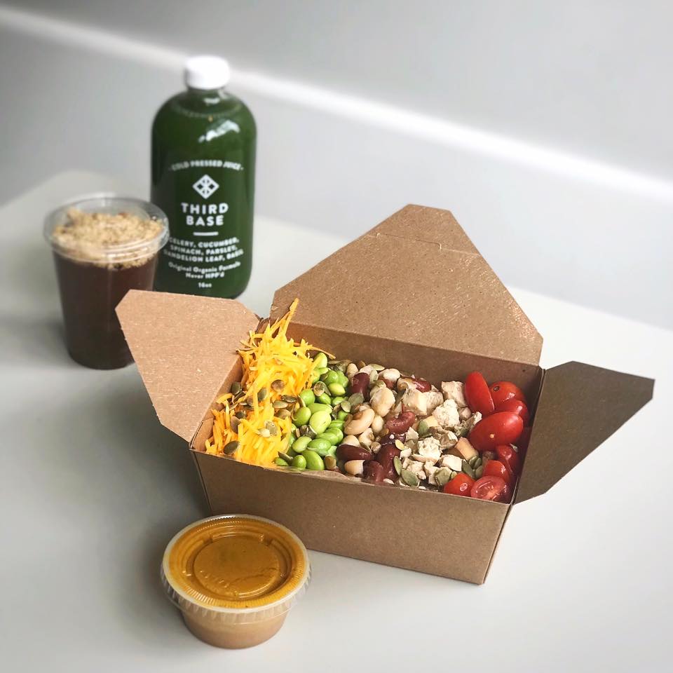 Compostable takeout lunch, a green juice, and to-go iced coffee on a white background