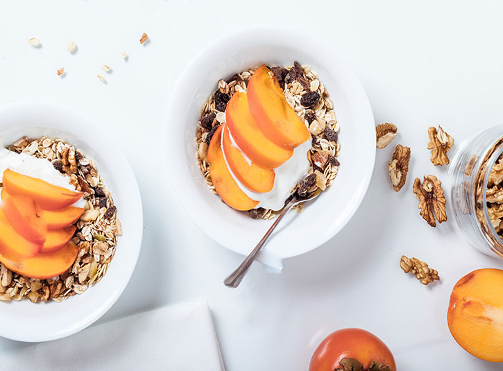 Healthy granola, nuts, yogurt, and persimmon bowls