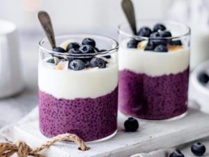 Purple chia seed smoothies with yogurt and berries on top 
