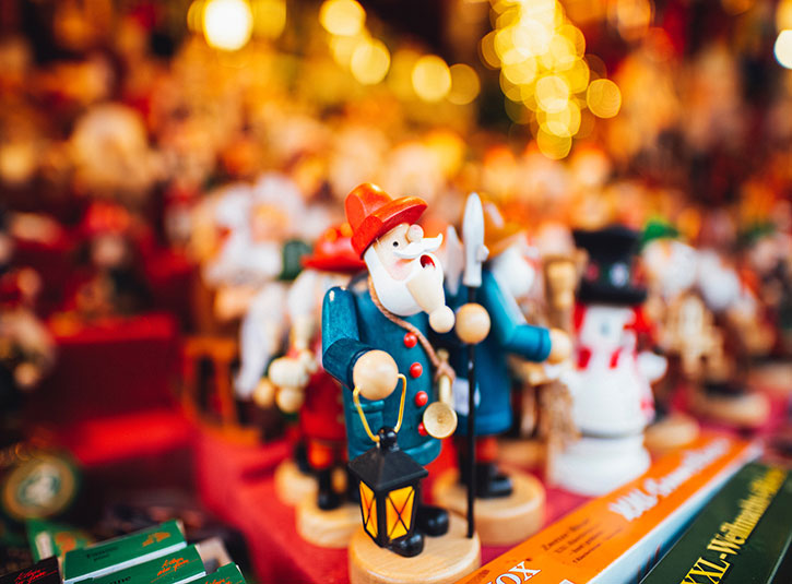 A festive holiday shop with wooden figurines and blurry christmas lights in the background