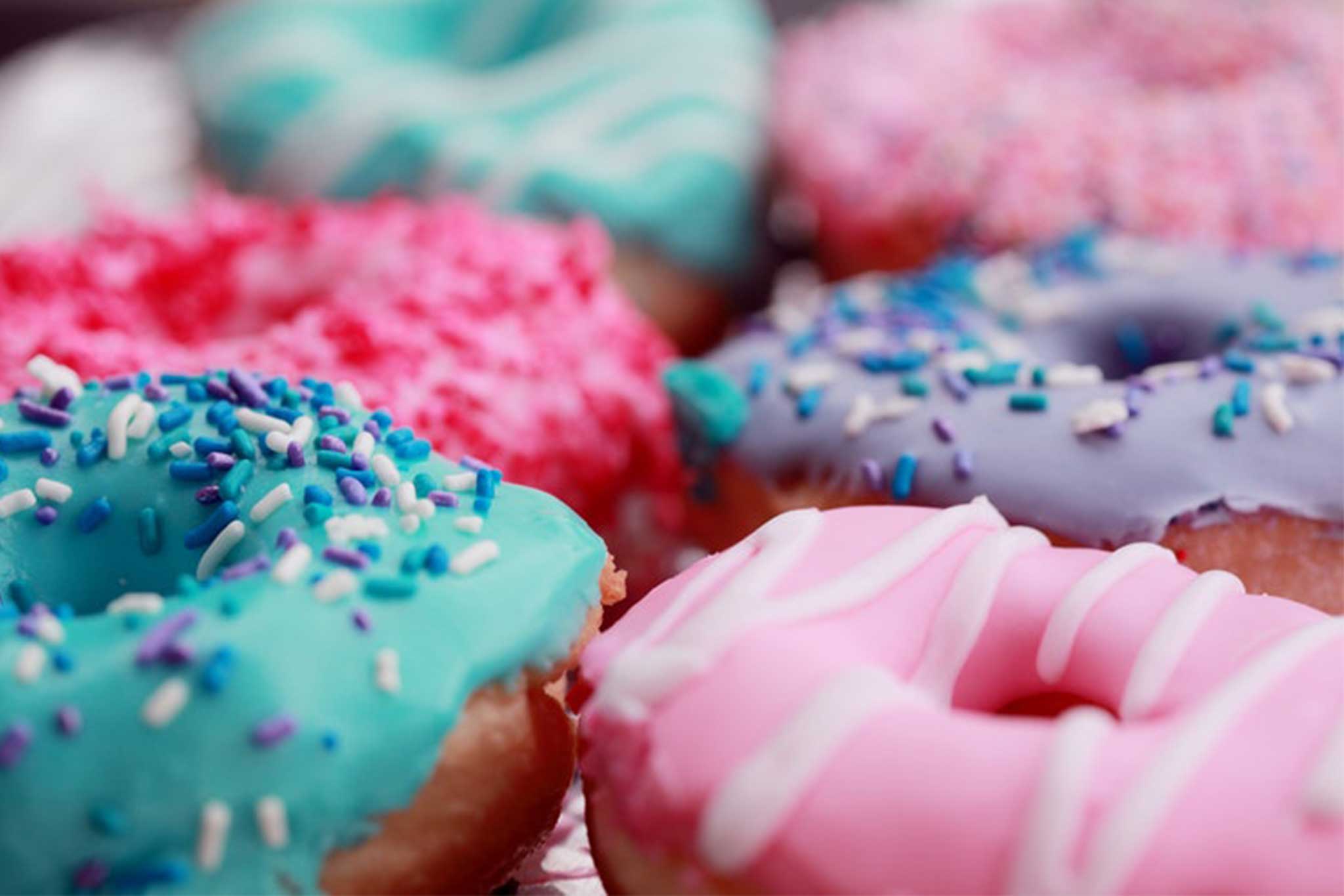 Donuts with pink, purple, and turquoise icing and sprinkles
