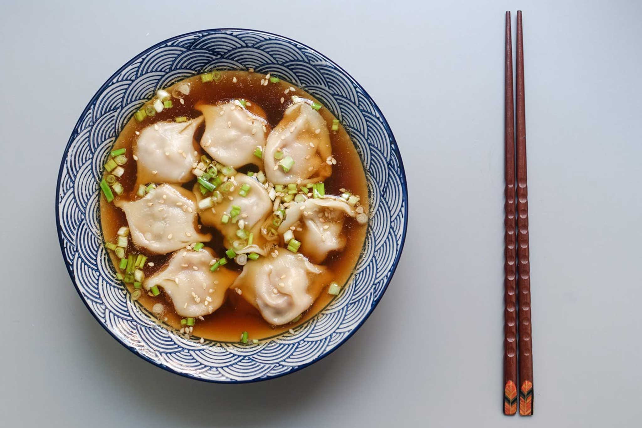 Dumpling soup in a bowl with chopsticks