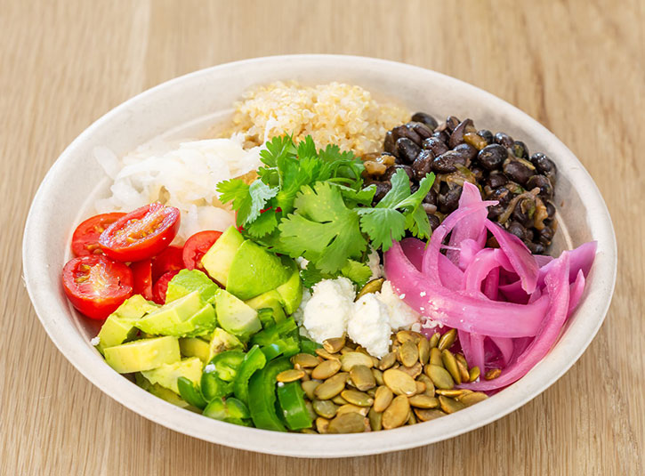 Healthy bowl with veggies, beans, rice, and pickled onions
