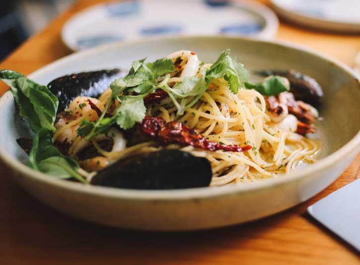 A bowl of vermicelli noodles with spices and herbs