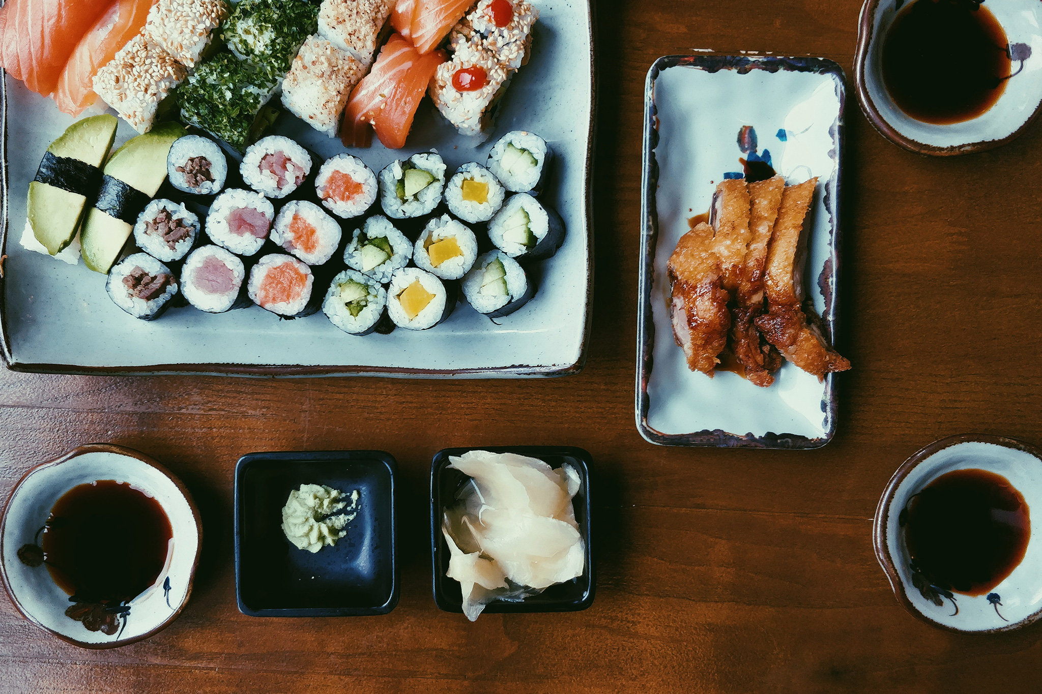 Platter of sushi and dipping sauces on a table