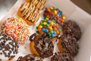 A box full of different donuts with lots of toppings