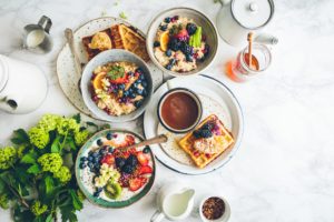 Breakfast dishes, coffee, and flowers on a tabletop