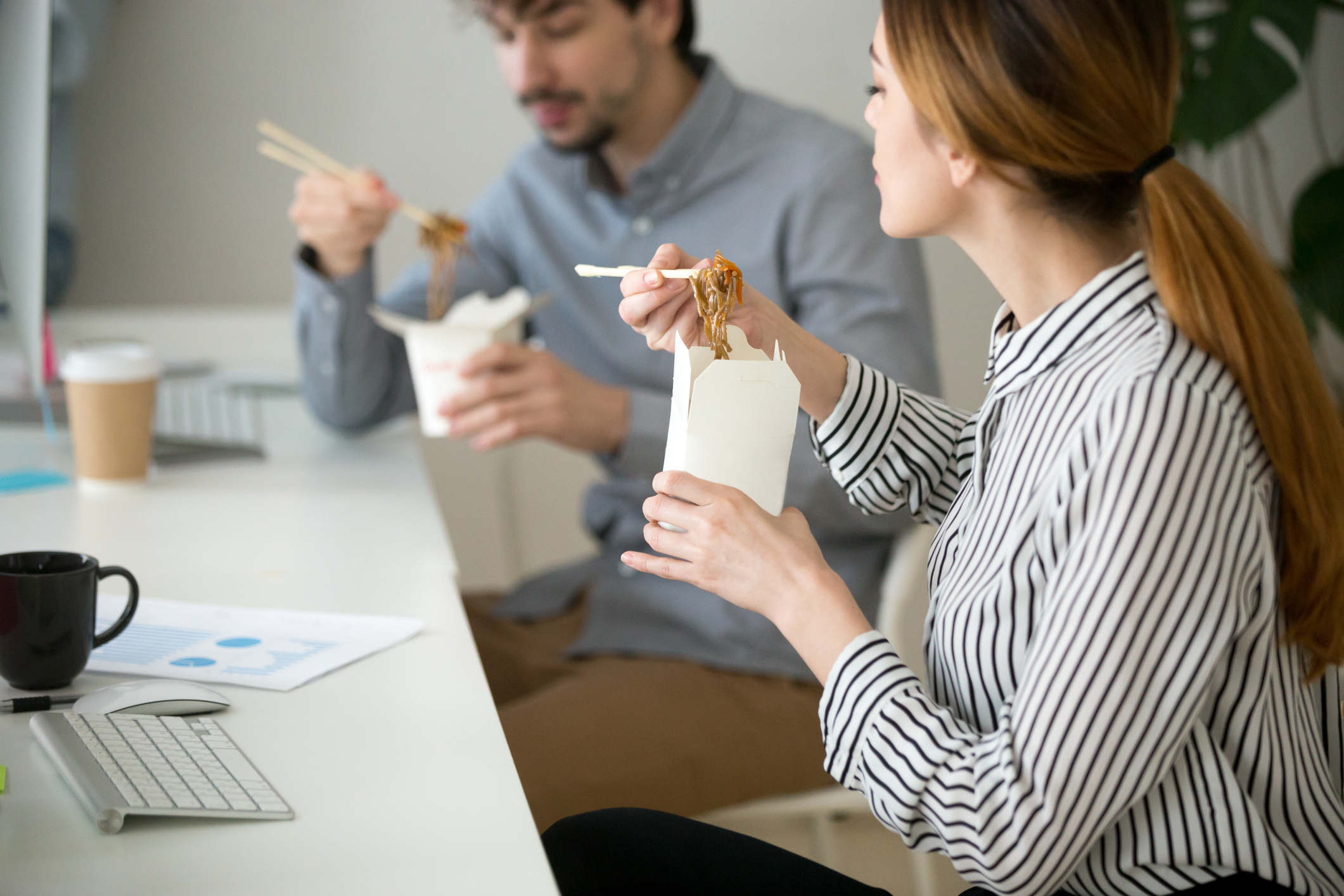 Office people eating chinese food in noodle box during lunch