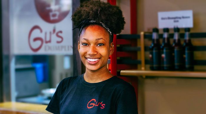 A server smiling from Gu's restaurant.