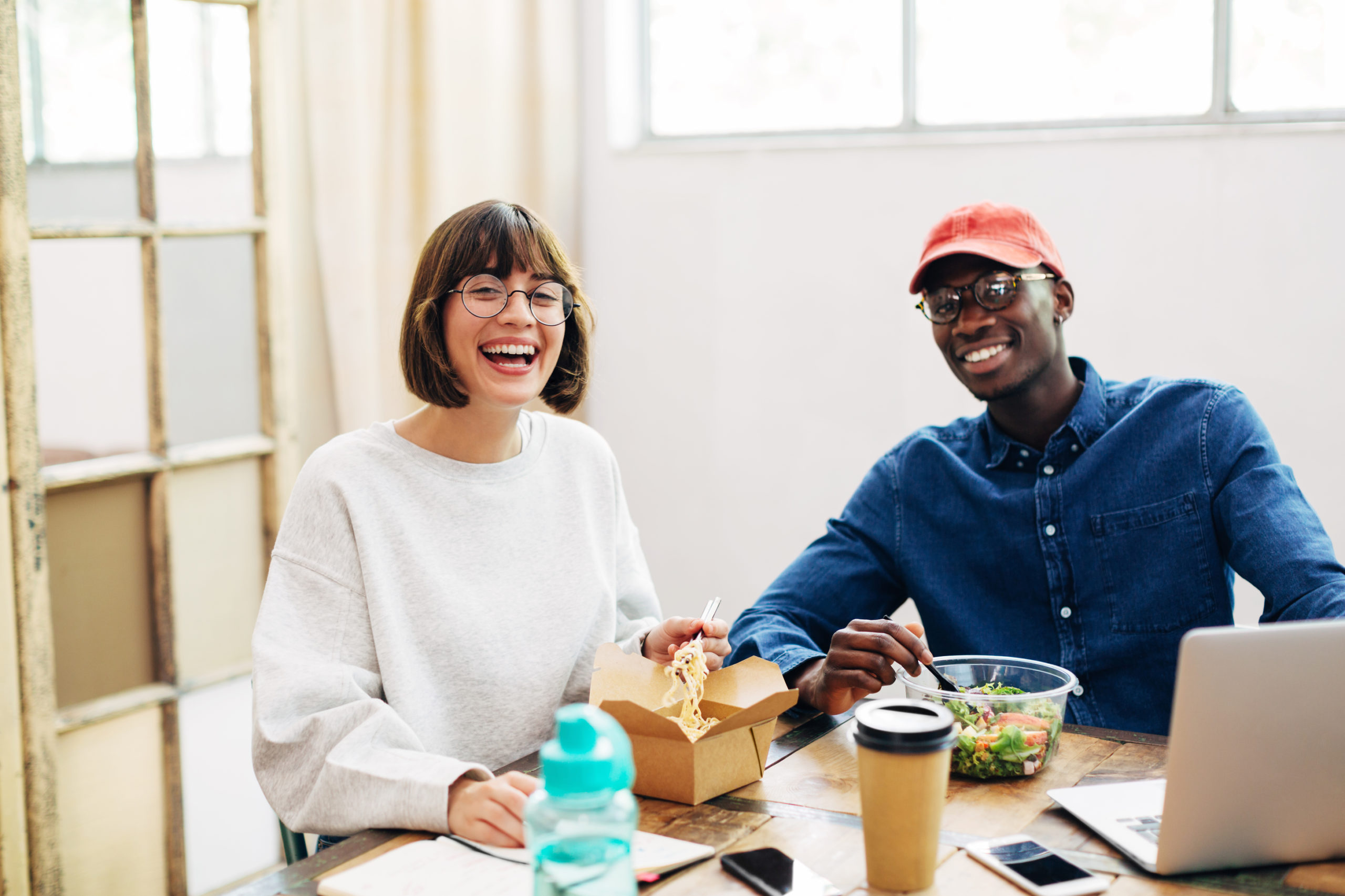 Two people laughing over a work lunch