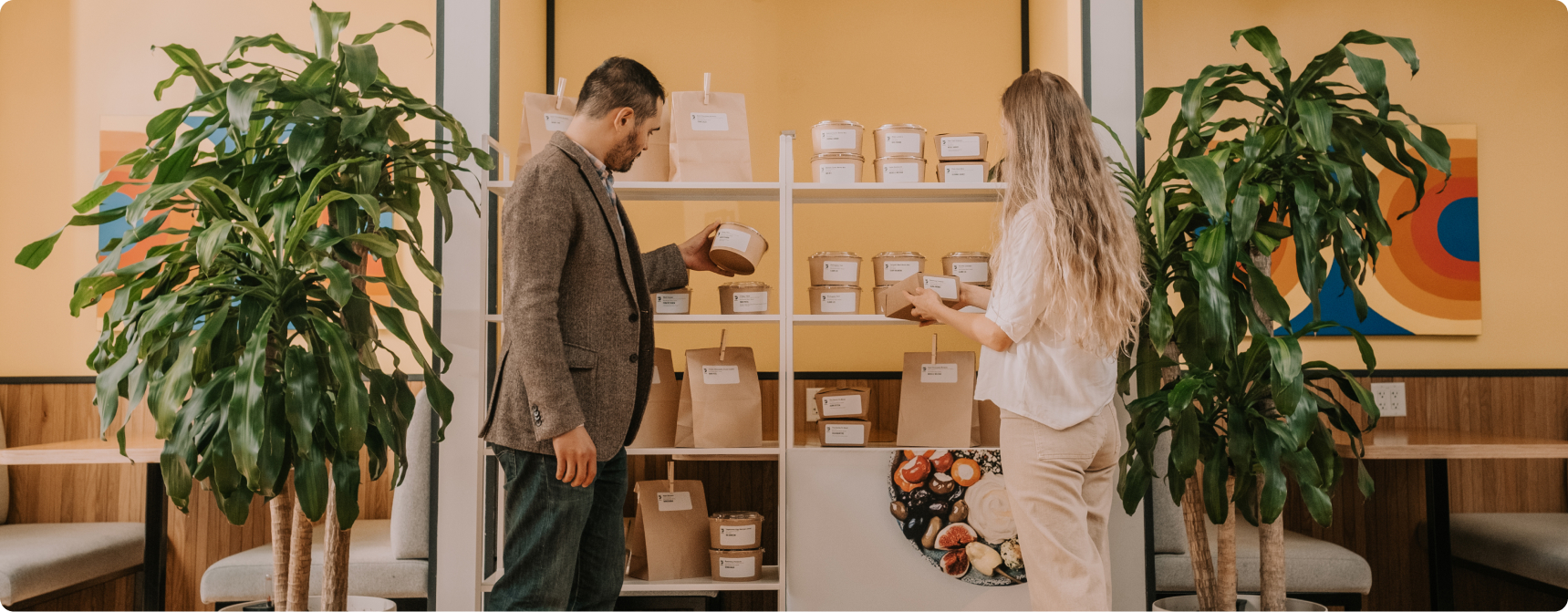 Two professionals selecting their individual pre-packaged Foodee meal from a shelf.