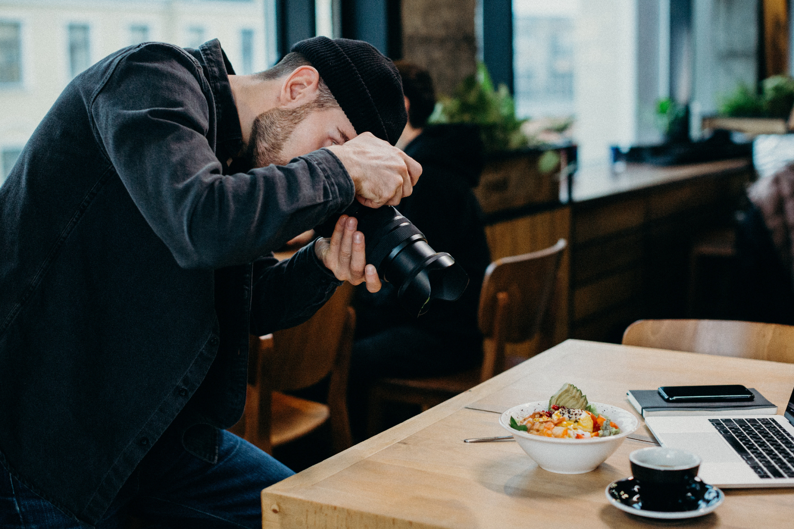 A professional photographer taking a photo of a bowl of food 