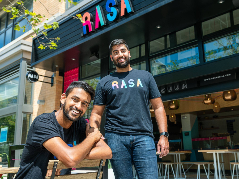 RASA Co-founders Rahul and Sahil posing in front of their restaurant front.