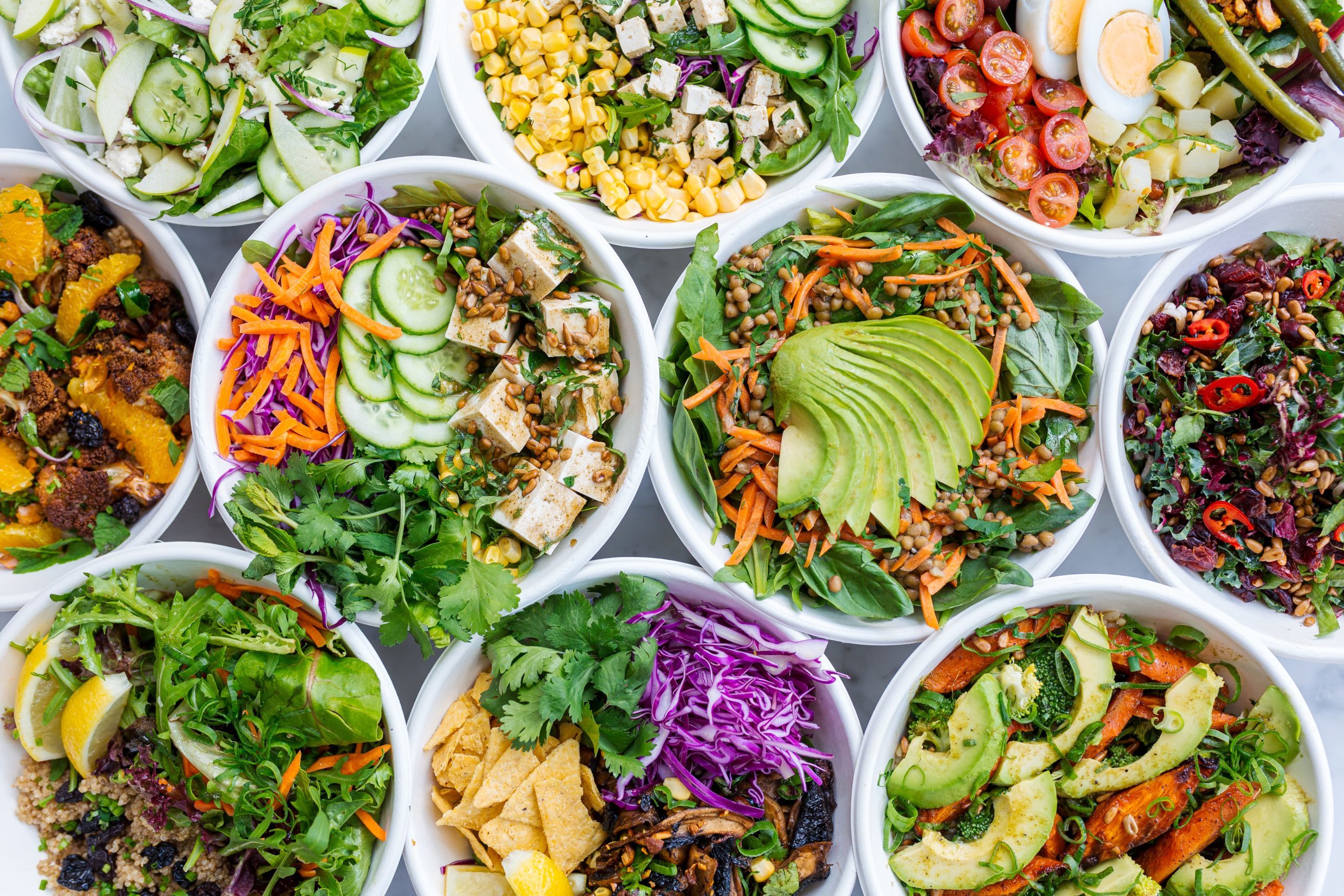 Many different salads in white bowls