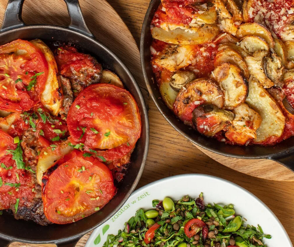 The Potato and Chicken and the Kafta in a Pan homemade skillets placed side by side on the table.