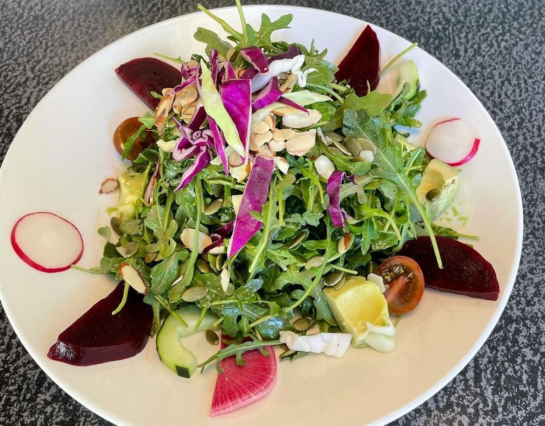 Modern-looking salad with beets, radishes, arugula, and sliced almonds
