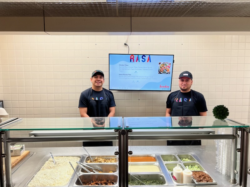 Rasa restaurant owners standing in front of store front.