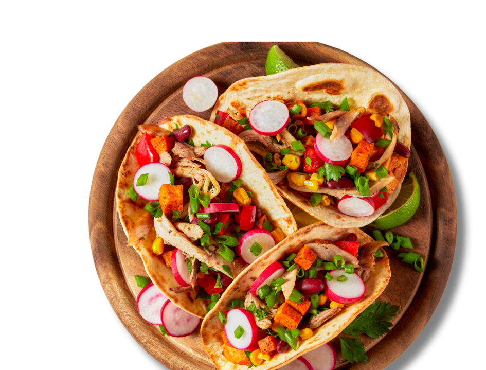 Three tacos on a circular wooden plate.