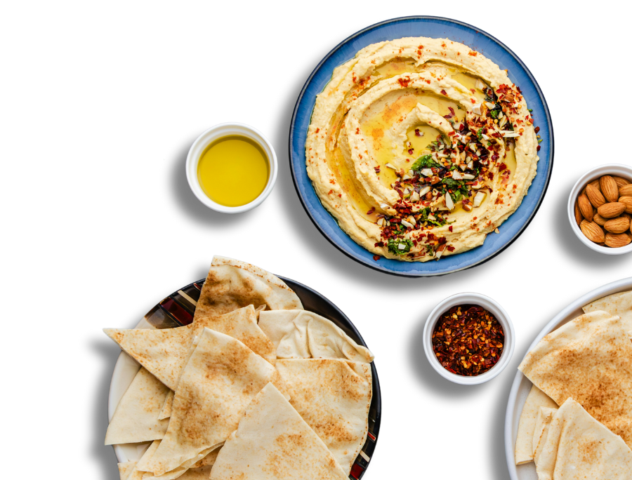 A plate of hummus with slides pita.