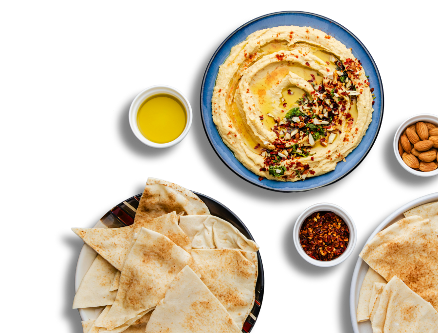 A plate of hummus with slides pita.