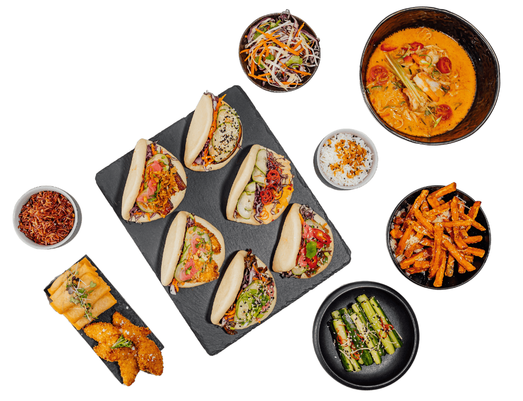 Plates of kimchi, cucumbers, spring rolls, tacos.